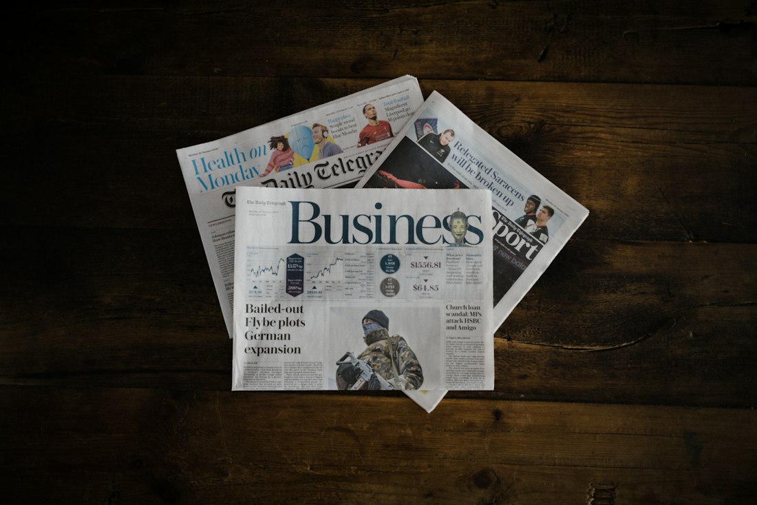 Business newspapers on a wooden table; illustrative photograph