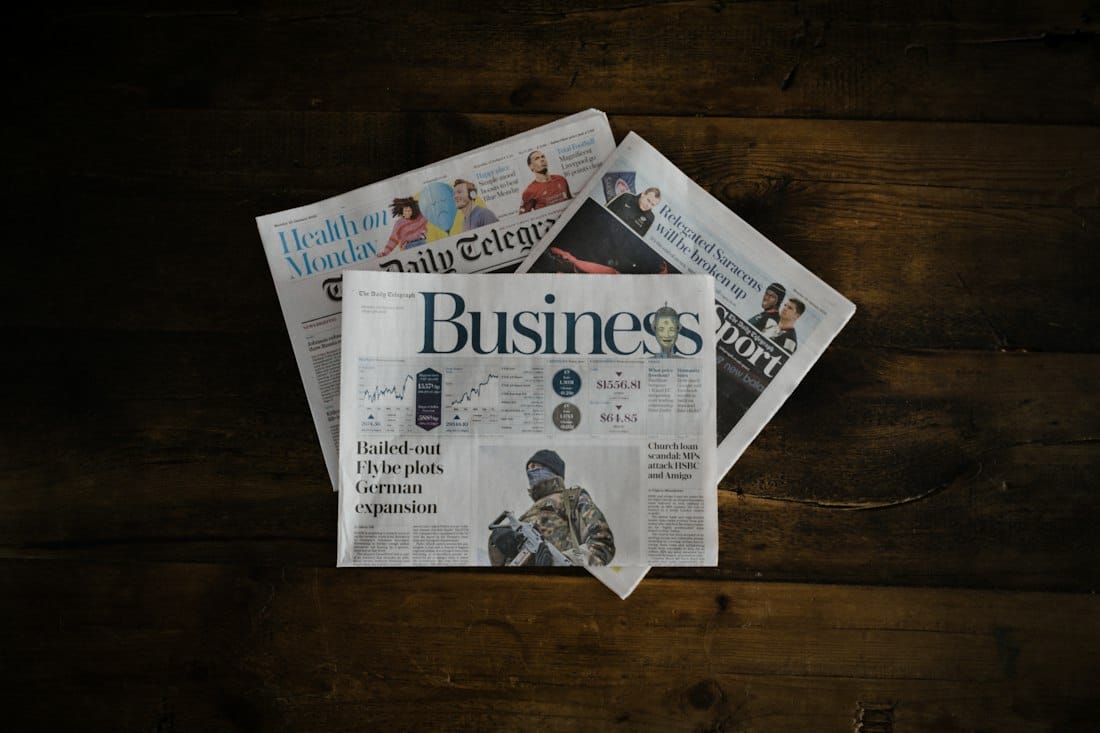 Business newspapers on a wooden table; illustrative photograph